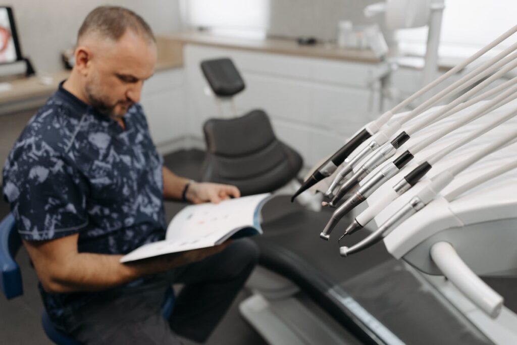 Man Sitting with Book by Dental Chair