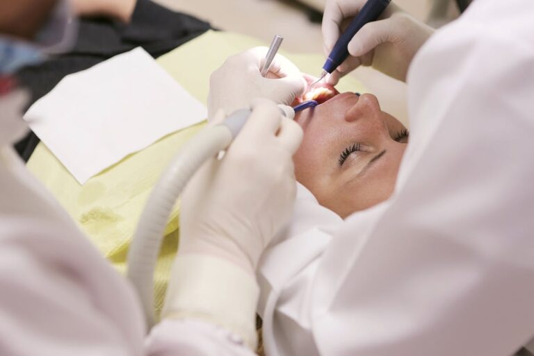 People Wearing White Shirt Working on Womans Teeth