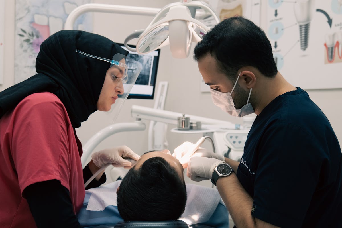 Dentist and a Nurse Treating a Patient in a Dental Clinic