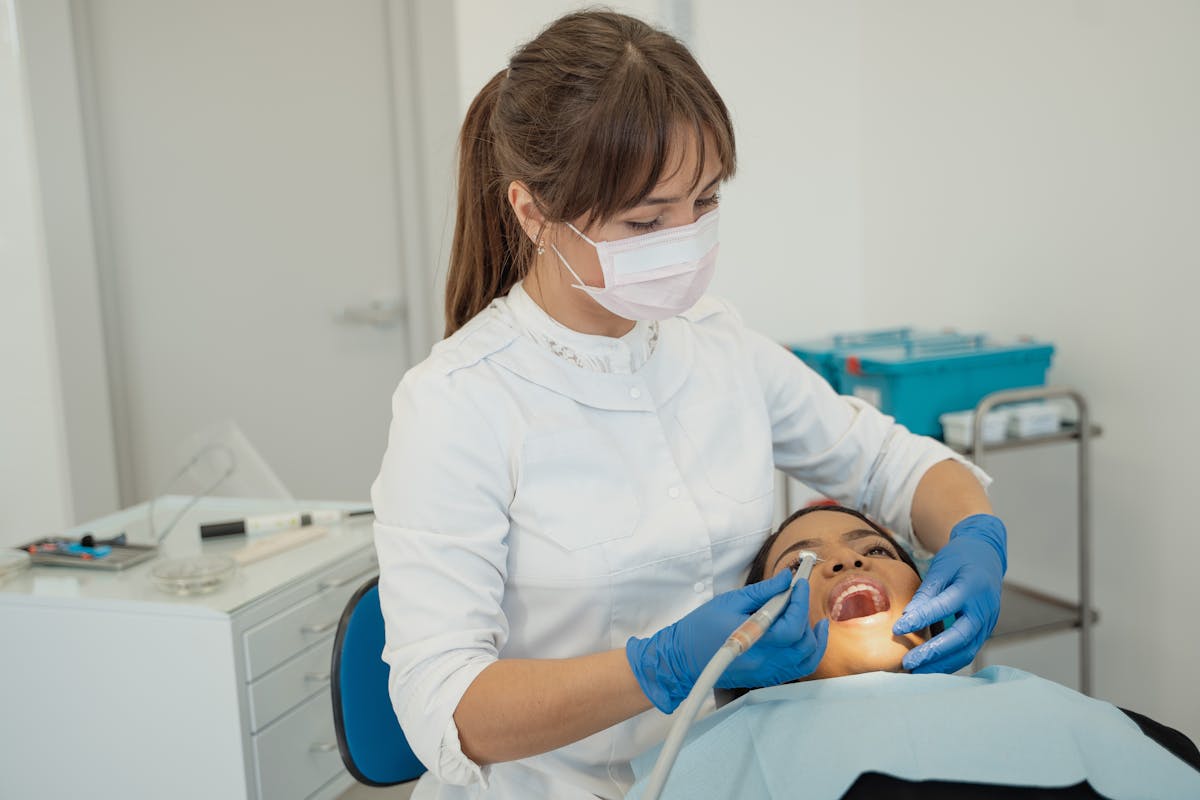 Woman in White Long Sleeve Shirt Checking the Teeth