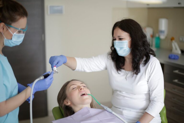 Woman lying in chair while getting treatment in dental clinic