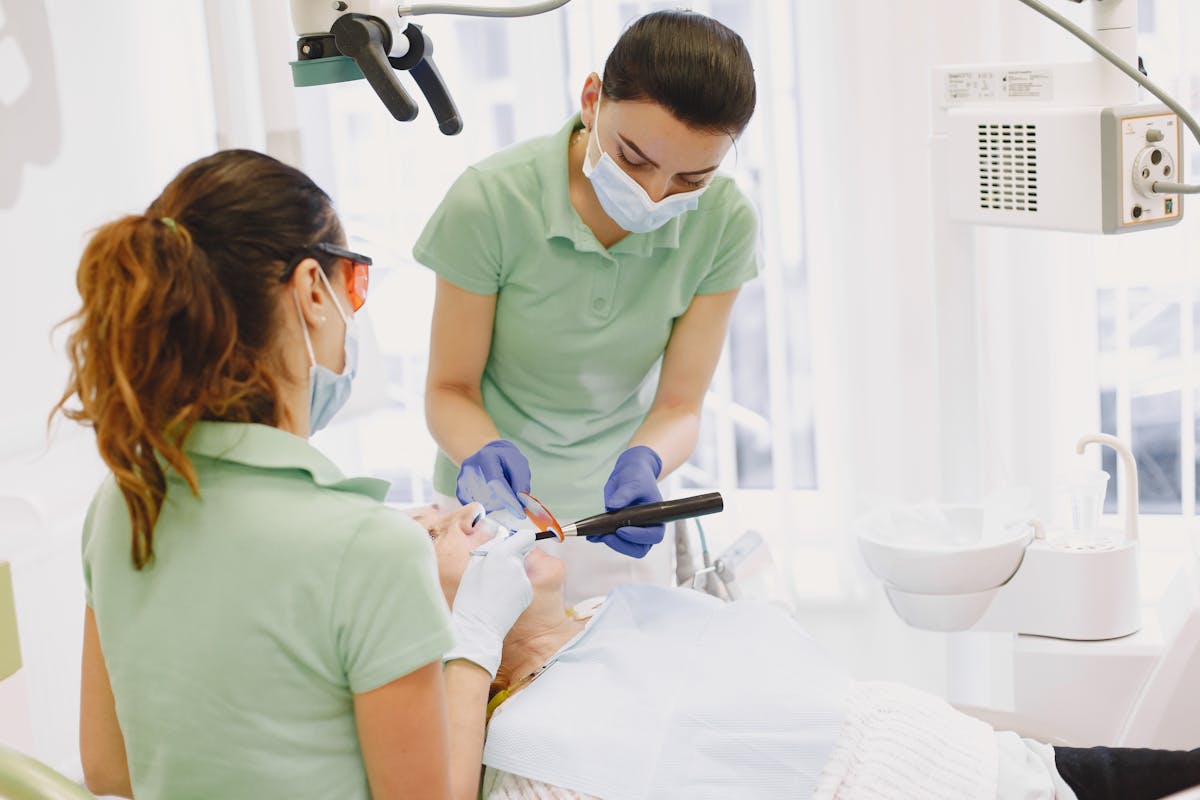 Women Performing Dental Procedures on Patient