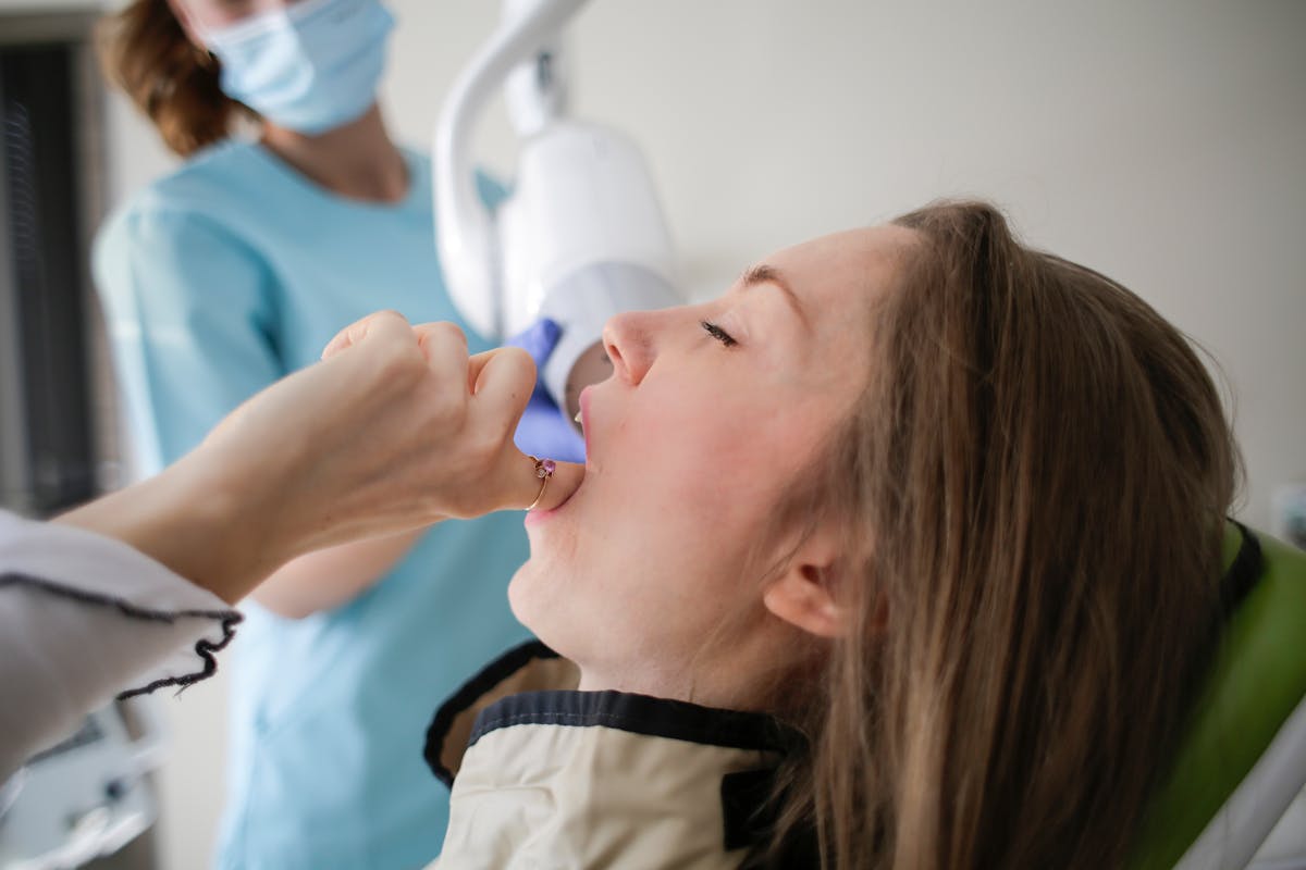 Crop unrecognizable orthodontist treating patents teeth in clinic